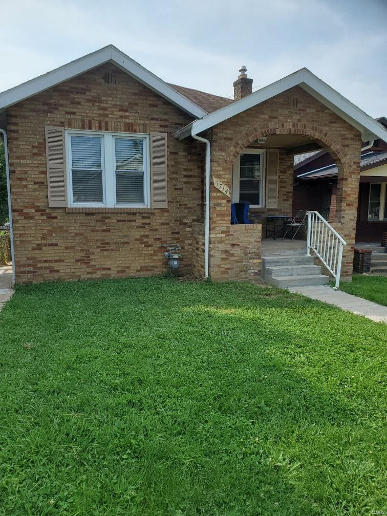 5714 Pamplin Pl, Saint Louis, MO 63136 - ranch-style home featuring brick siding, a front yard, and a chimney