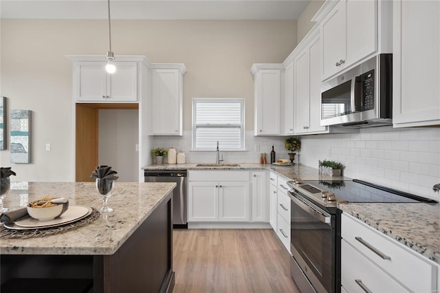 4947 Butler Hill Rd, Saint Louis, MO 63128 - kitchen with stainless steel appliances, a sink, white cabinets, decorative backsplash, and light stone counters