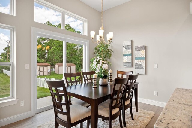4947 Butler Hill Rd, Saint Louis, MO 63128 - dining area featuring a chandelier, light wood-style floors, baseboards, and a high ceiling