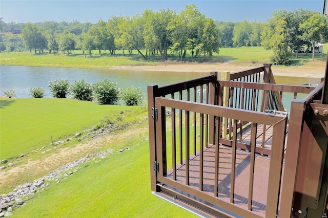 gate featuring a yard and a deck with water view