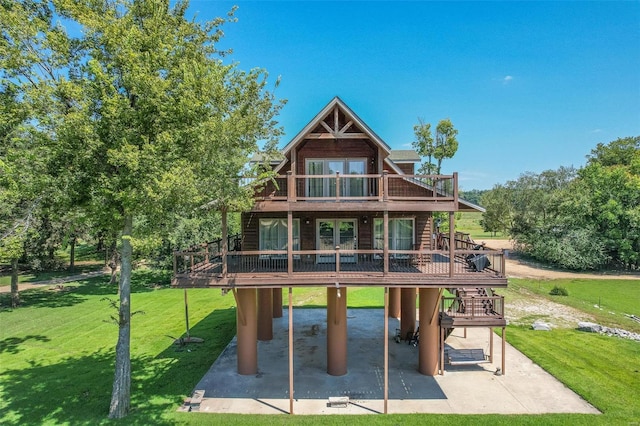 rear view of house with a patio area, a deck, a yard, and french doors