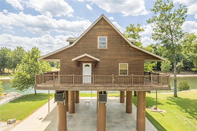 exterior space with a front lawn, a deck with water view, central air condition unit, and a patio