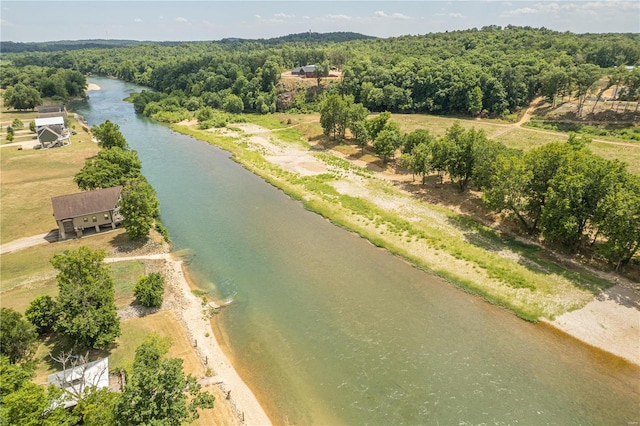 drone / aerial view of a large body of water and a heavily wooded area