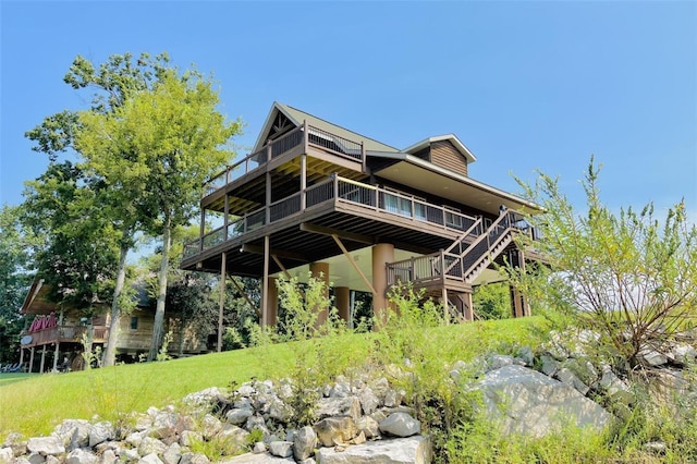 rear view of property featuring a deck, stairs, and a yard