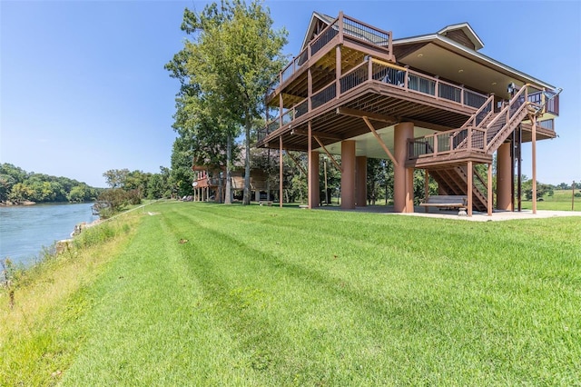 surrounding community with a yard, a deck with water view, and stairway