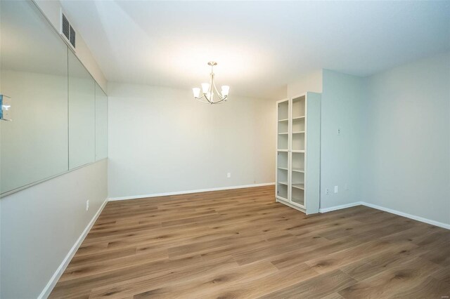 13579 Coliseum Dr Unit G, Chesterfield, MO 63017 - spare room with a chandelier, baseboards, and wood finished floors