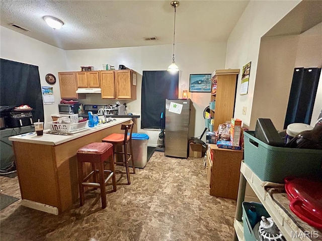 410 N Main St, Red Bud, IL 62278 - kitchen with under cabinet range hood, a breakfast bar, pendant lighting, appliances with stainless steel finishes, and tile patterned floors