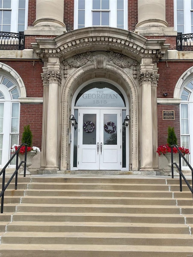 entrance to property featuring brick siding and french doors