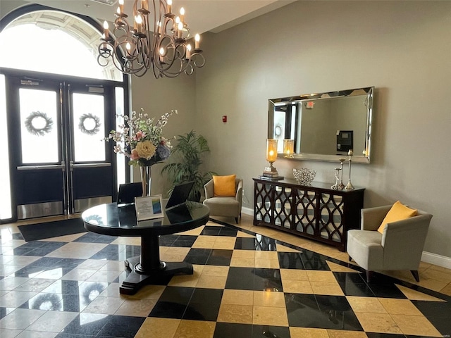 foyer with baseboards, a chandelier, and lofted ceiling