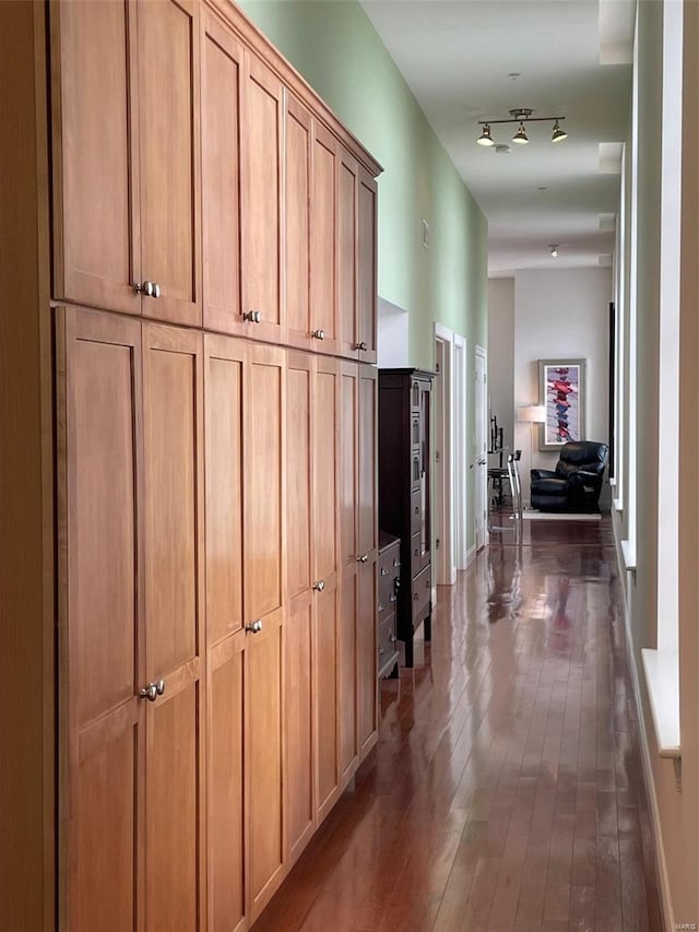 hallway with dark wood-style flooring and baseboards