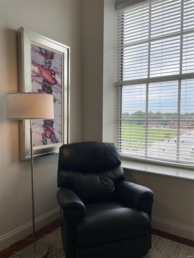 sitting room with healthy amount of natural light, baseboards, and wood finished floors
