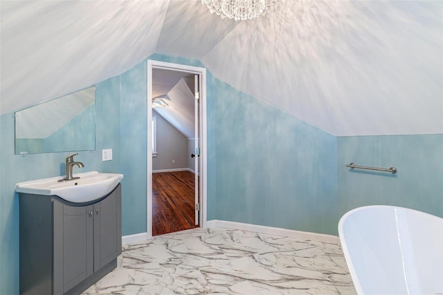 371 Jefferson St, Saint Genevieve, MO 63670 - bathroom featuring lofted ceiling, a freestanding bath, vanity, marble finish floors, and baseboards