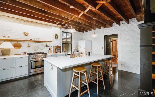 725 W Springfield St, St James, MO 65559 - kitchen with stainless steel stove, light countertops, wooden ceiling, an island with sink, and a sink