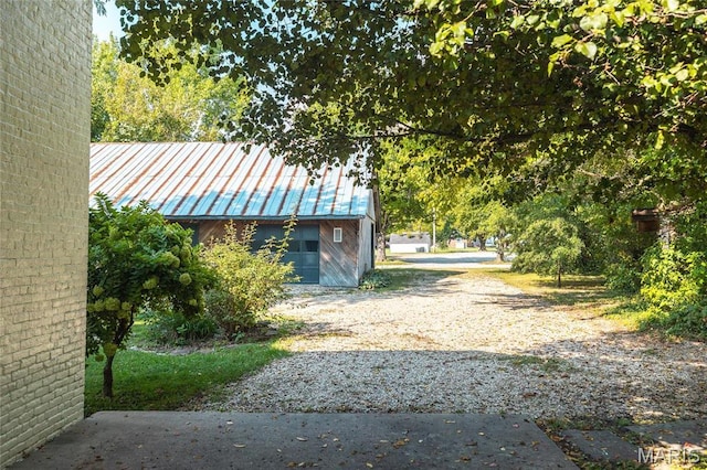 725 W Springfield St, St James, MO 65559 - view of side of home with driveway, metal roof, and an outdoor structure