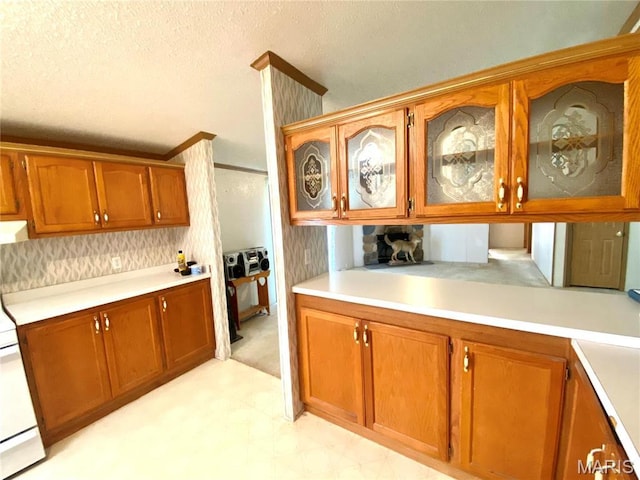 610 N Caldwell St, Middletown, MO 63359 - kitchen featuring brown cabinets, light countertops, glass insert cabinets, light flooring, and a textured ceiling