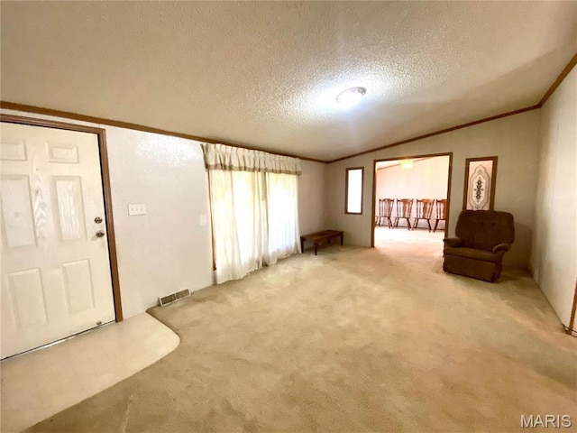 610 N Caldwell St, Middletown, MO 63359 - unfurnished living room featuring light carpet, ornamental molding, lofted ceiling, and a textured ceiling