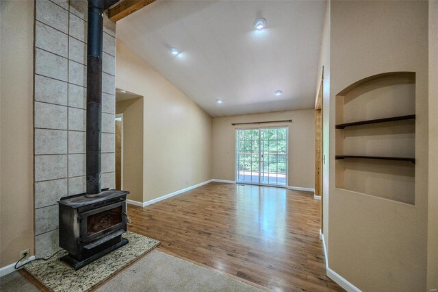 28 Acacia Dr, Conway, MO 65632 - unfurnished living room with a wood stove, vaulted ceiling, wood finished floors, baseboards, and built in shelves
