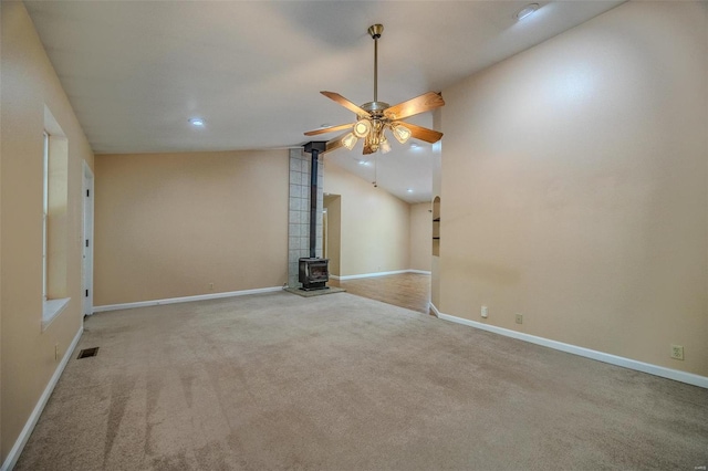 28 Acacia Dr, Conway, MO 65632 - unfurnished room featuring a wood stove, carpet flooring, ceiling fan, lofted ceiling, and baseboards