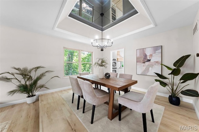 6 Freedom Way, Saint Charles, MO 63303 - dining space featuring a chandelier, light wood-style flooring, a tray ceiling, and baseboards