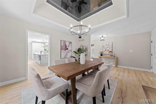 6 Freedom Way, Saint Charles, MO 63303 - dining room with a chandelier, light wood-style floors, a tray ceiling, and baseboards