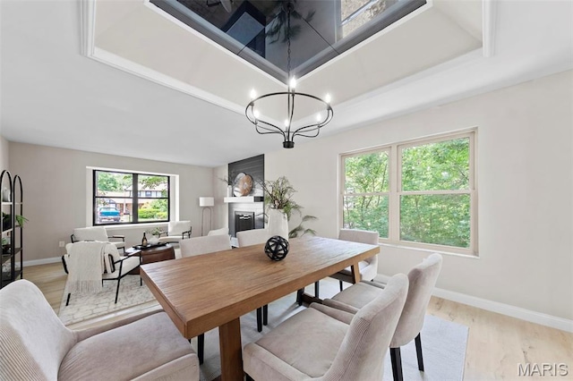 6 Freedom Way, Saint Charles, MO 63303 - dining room with a fireplace, light wood finished floors, baseboards, and a chandelier