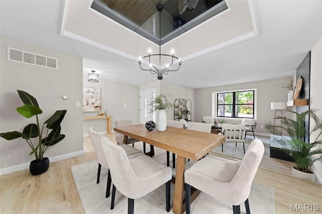 6 Freedom Way, Saint Charles, MO 63303 - dining room featuring a chandelier, light wood-style flooring, a tray ceiling, and baseboards