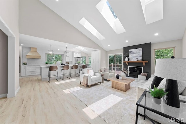 6 Freedom Way, Saint Charles, MO 63303 - living area with light wood-style floors, recessed lighting, a skylight, high vaulted ceiling, and a fireplace