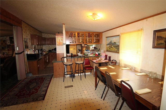 12433 State Route 101, Caulfield, MO 65626 - dining room featuring vaulted ceiling, light floors, wallpapered walls, ornamental molding, and a textured ceiling