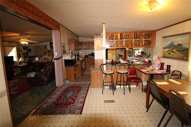12433 State Route 101, Caulfield, MO 65626 - dining area featuring light flooring, a textured ceiling, ceiling fan, and wallpapered walls