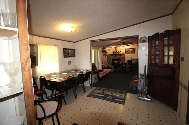 12433 State Route 101, Caulfield, MO 65626 - carpeted dining room with vaulted ceiling, crown molding, a stone fireplace, ceiling fan, and a textured ceiling
