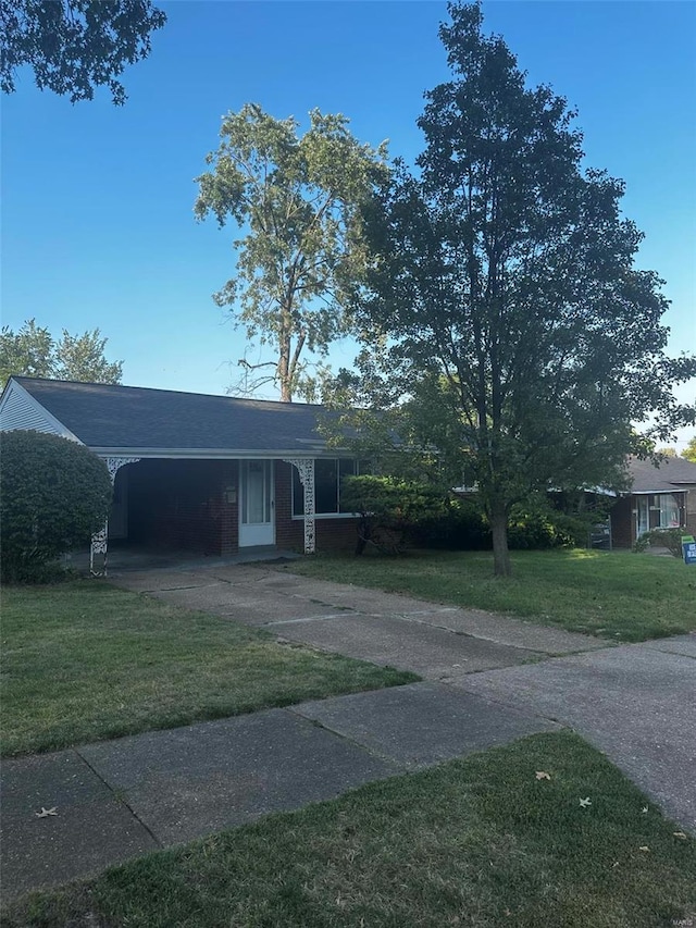 view of front of property featuring a front yard, driveway, and a carport