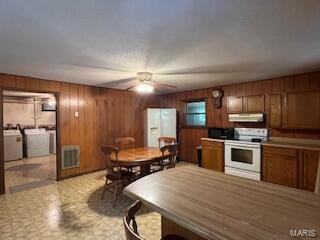 1742 Date Dr, Summersville, MO 65571 - kitchen featuring white electric range oven, under cabinet range hood, brown cabinetry, independent washer and dryer, and wooden walls