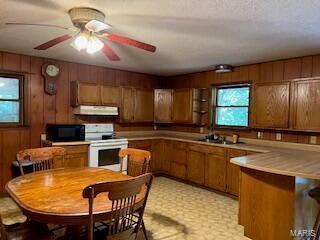 1742 Date Dr, Summersville, MO 65571 - kitchen featuring white range with electric cooktop, under cabinet range hood, black microwave, brown cabinetry, and a ceiling fan