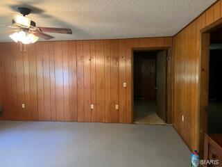 1742 Date Dr, Summersville, MO 65571 - carpeted empty room with a ceiling fan, wooden walls, and a textured ceiling