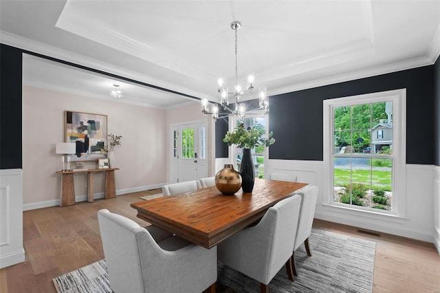 1315 Breezeridge Dr, Saint Louis, MO 63131 - dining area featuring a tray ceiling, a chandelier, light wood-style flooring, crown molding, and wainscoting