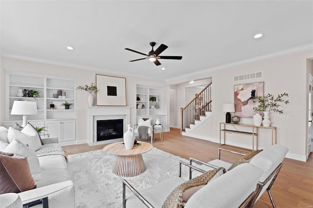 1315 Breezeridge Dr, Saint Louis, MO 63131 - living area featuring crown molding, light wood-style flooring, a ceiling fan, stairway, and built in shelves