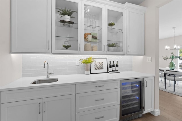 1315 Breezeridge Dr, Saint Louis, MO 63131 - indoor bar featuring wine cooler, wood finished floors, decorative backsplash, a chandelier, and hanging light fixtures