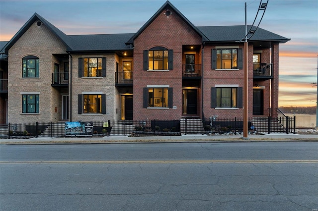 292 N Main St, Cape Girardeau, MO 63701 - view of front facade featuring a fenced front yard, brick siding, and a balcony