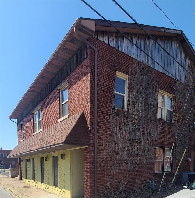 14 N 6th St, Wood River, IL 62095 - view of side of home with brick siding, central AC, and board and batten siding