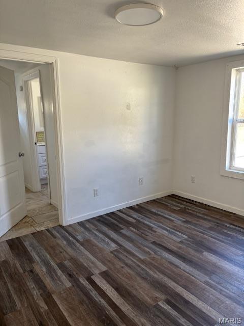 1439 N Spanish St, Cape Girardeau, MO 63701 - unfurnished room featuring dark wood finished floors, baseboards, and a textured ceiling