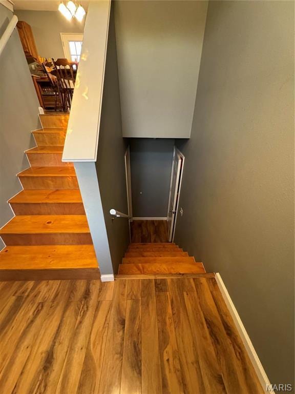 stairs featuring wood finished floors and baseboards