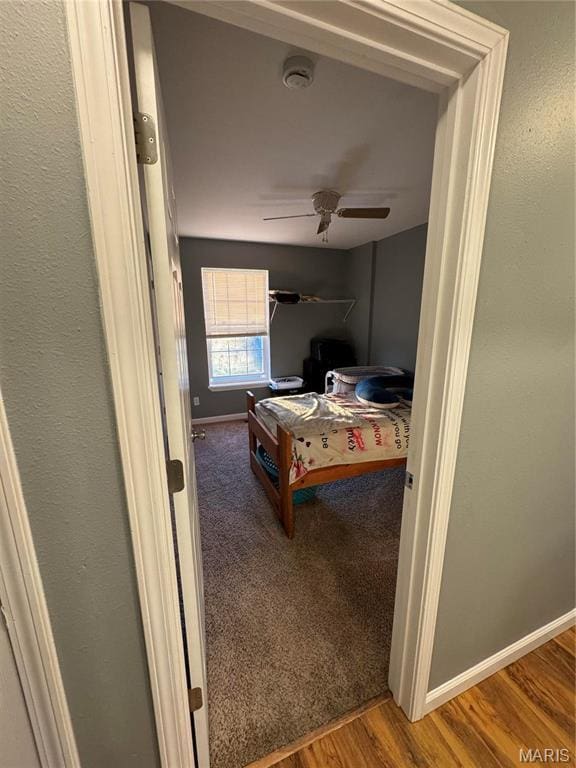 hallway with baseboards and wood finished floors