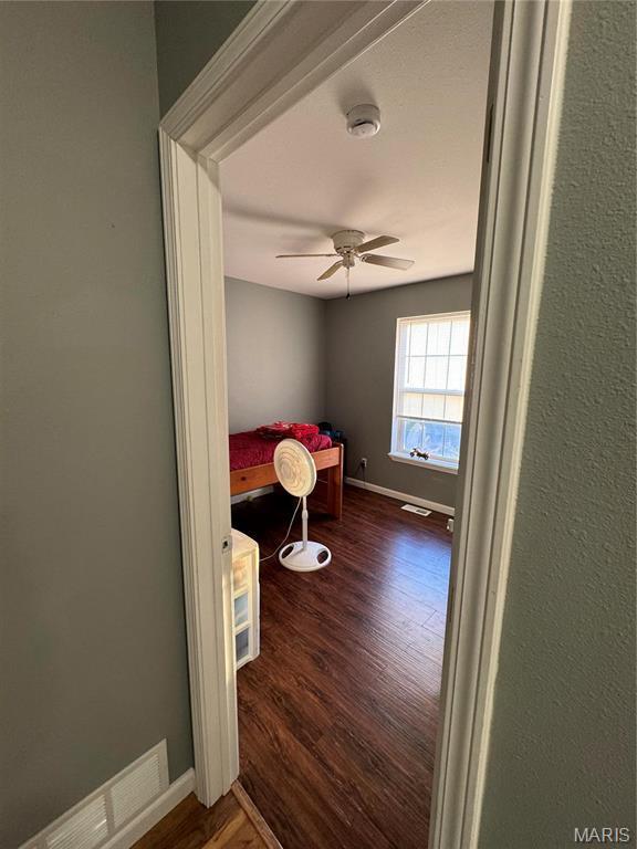 bedroom with wood finished floors, baseboards, and a ceiling fan