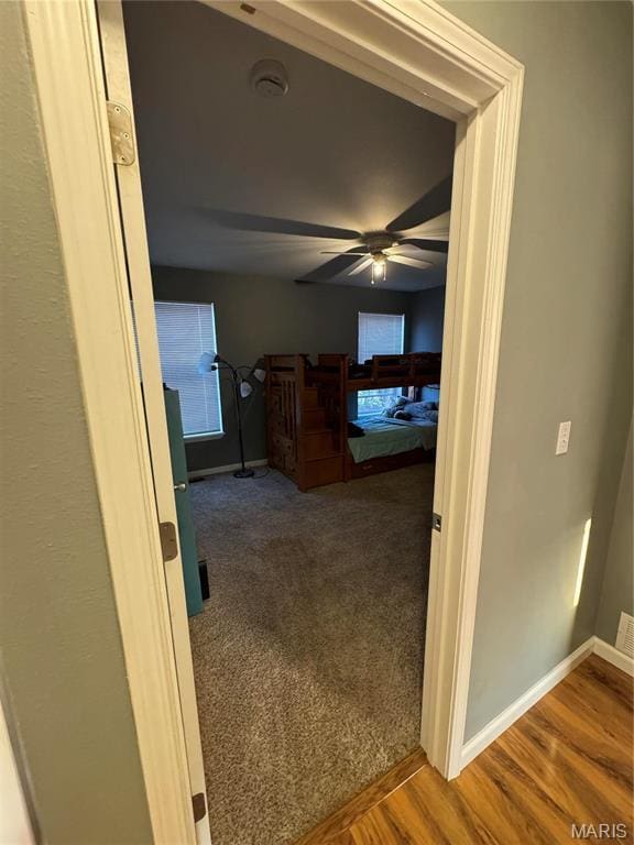 hall with baseboards and wood finished floors