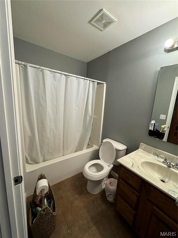 full bathroom featuring tile patterned floors, shower / tub combo, toilet, and vanity