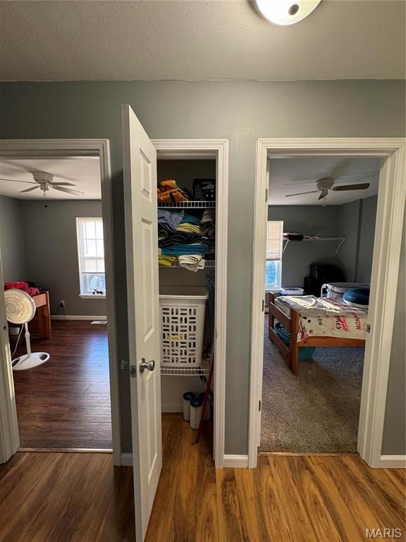 corridor with wood finished floors and baseboards