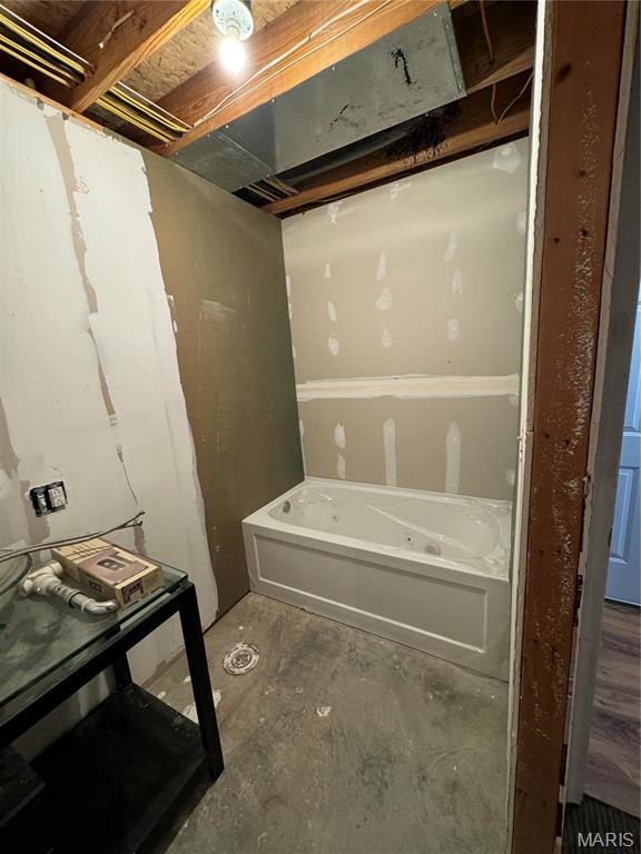full bathroom with a tub to relax in and concrete flooring
