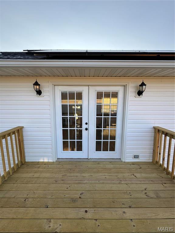 entrance to property featuring french doors and a wooden deck