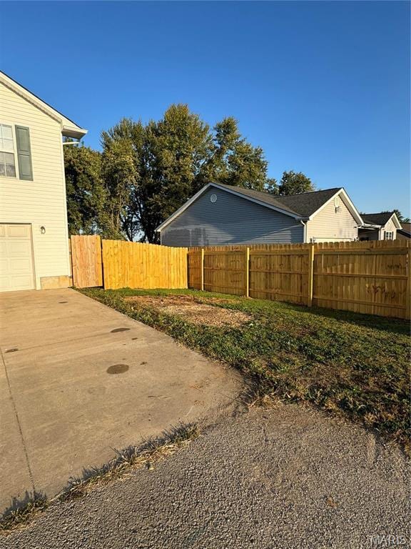 view of home's exterior with fence and concrete driveway