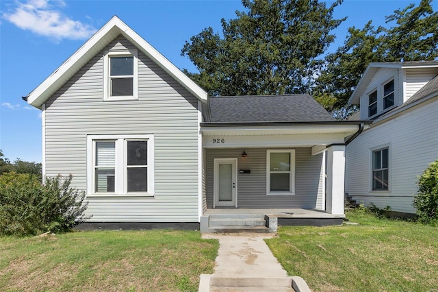 view of front of home with a porch, a front yard, and a shingled roof